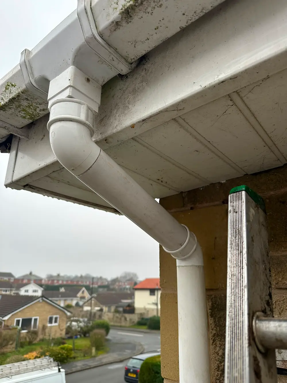 A fresh white downpipe run on a stone house.