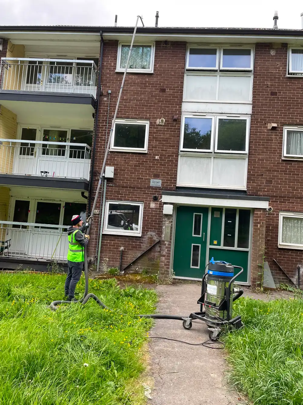 A high reach vacuum unit and hose set up at ground level.
