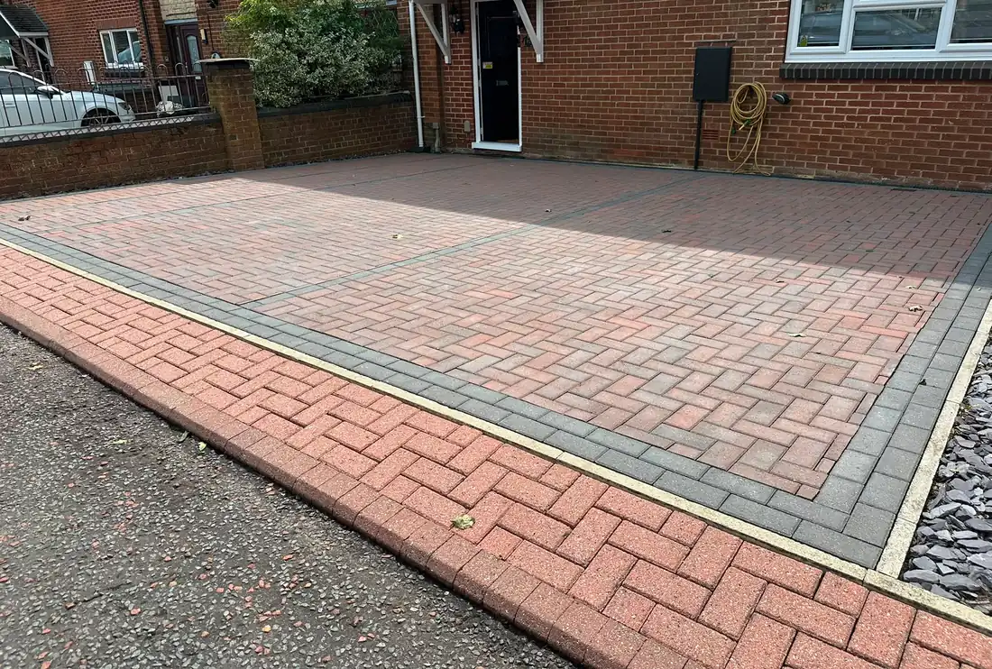 A block paved driveway finished with a contrasting kerb detail.