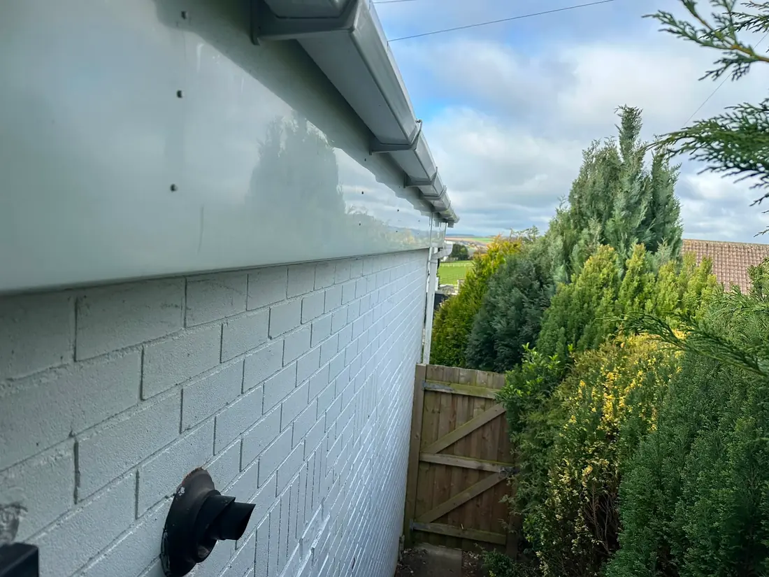 Fascia and guttering on a rural bungalow with a valley view behind.