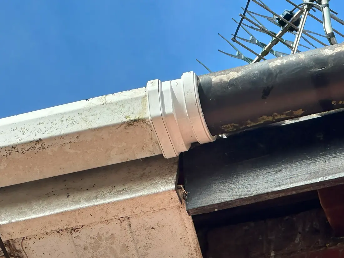 A new downpipe collar fitted into an old cast iron downpipe.