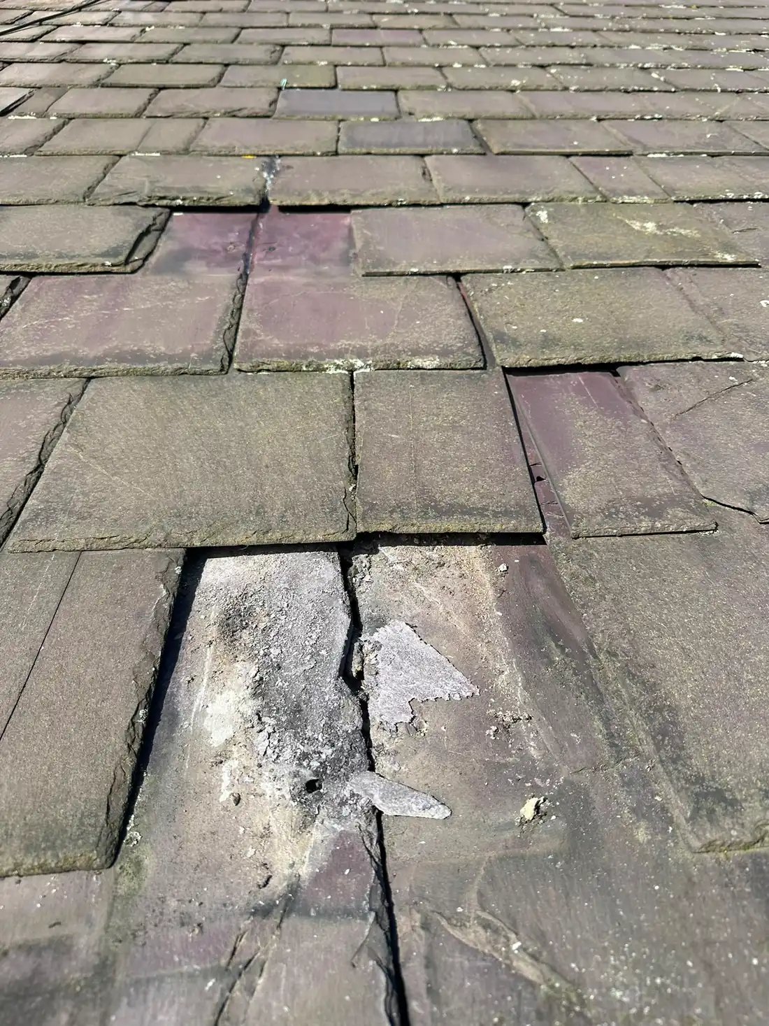 Slate roof tiles refixed with new lead tingles.